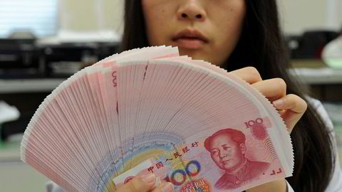 En bankansatt teller kinesiske yuan. Foto: Reuters/stringer/NTB scanpix