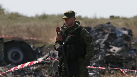 PÅ VAKT: En væpnet separatist vokter vrakrestene etter det malaysiske flyet som ble skutt ned søt i Ukraina forrige uke. Foto: Maksim Zmejev / Reuters / NTB scanpix