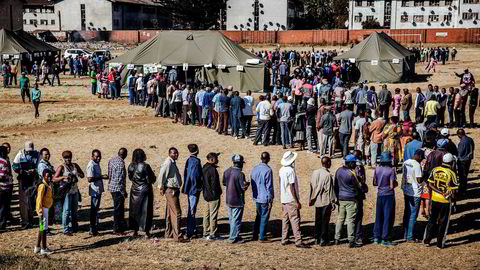 Folk står i kø utenfor valglokalene i utkanten av hovedstaden Harare i Zimbabwe 30. juli. Befolkningen skal stemme ved det første valget siden landets mangeårige leder Robert Mugabe ble avsatt. Nå skal det velges både ny president og nasjonalforsamling.