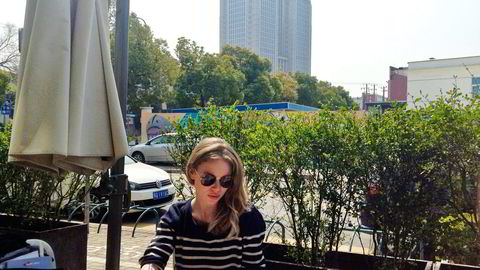 GIR REISETIPS. Språkstudent Tonje Kjellevold leser lekser i solen i Shanghai. I bakgrunnen er Guanghua-bygget hvor hun har undervisning. Alle foto: Privat
