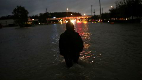 En person vasser med vann til hoftene gjennom natten i Houston, en av svært mange som må evakuere etter at orkanen Harvey  traff land fredag. Nå stiger dødstallene.