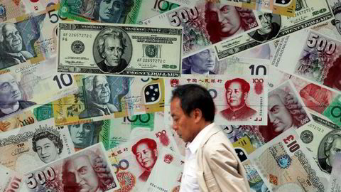 VALUTA: Kina Yuan En mann går forbi en reklame for valutaveksling i Hongkong. Foto: Tyrone Siu/Reuters/NTB scanpix