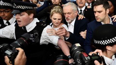 Labour-leder Jeremy Corbyn fotografert idet politifolk hjelper ham gjennom folkemengden før han skal tale til tilhengerne på Parliament Square i London mandag kveld. Foto: Toby Melville / Reuters / NTB scanpix