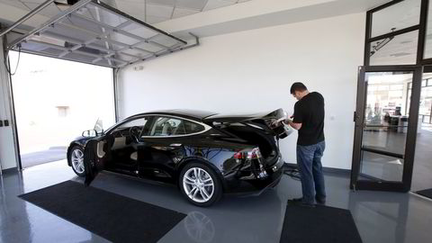 En ansatt klargjør en bil i hos en Tesla-forhandler i Salt Lake City, USA. REUTERS/George Frey