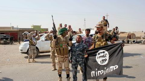 FIKK STØTTE. Soldater fra en irakisk sjiamilits holder er IS-flagg etter at den inntok bye Amerli. USA støttet operasjonen med bombeangrep. Foto: AP Photo