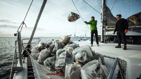 De to frivillige Frederick Anthony Bernet og Asgeir Johansen tar søppel fra fjæra om bord i seilbåten til Pukka Travel.