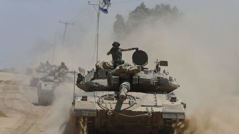 TREKKES UT: Israel og palestinerne ble mandag kveld enige om at en våpenhvile skal tre i kraft klokken syv norsk tid. Bildet viser en israelsk stridsvogn ved Gazastripen søndag. Foto: