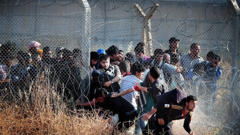 Det kan gå mot full kollaps av returavtalen mellom Tyrkia og EU, frykter eksperter. Siden avtalen trådte i kraft i mars, har andelen flyktninger til Europa falt kraftig. Bildet viser syriske flyktninger som presser seg gjennom grensegjerdet mot Tyrkia. Foto: Lefteris Pitarakis/Ap/NTB Scanpix