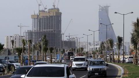 Saudi-Arabia vurderer å kutte subsidiene på bensin. På bildet kjører biler forbi en bygning under oppføring i kystbyen Jeddah. Foto: Khaled Saad/AFP photo/NTB scanpix