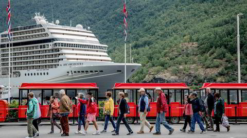 Et cruiseskip med 5000 gjester er et like stort fotavtrykk på miljøet som en by med 25.000 innbyggere. Her en gruppe turister foran et cruiseskip i Flåm.