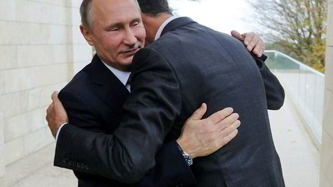 Russlands president Vladimir Putin, omfavner Syrias president Bashar al-Assad i Svartehavsbyen Sotsji mandag.