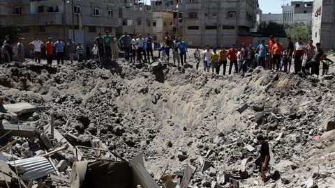 Innbyggere i bydelen Zeitoun i Gaza by ser på et krater, som ifølge vitner skal stamme fra israelske bomber fredag 8. august 2014. Foto: Siegfried Modola, AFP / NTB scanpix