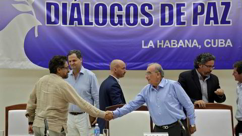 Den colombianske regjeringens sjefforhandler, Humberto de la Calle (t.v.), håndhilste på sin motpart fra FARC, Ivan Marquez, etter at de nylig skrev under en avtale om å avvæpne geriljagruppen. Nå er også fredsavtalen mellom staten og geriljaen klar. Arkivfoto: Enrique De La Osa / Reuters / NTB scanpix