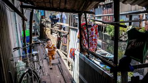 En gutt leker i gangområdet til et hus på elvebredden ved Xuyen Tam-kanalen i Ho Cho Minh City i Vietnam.