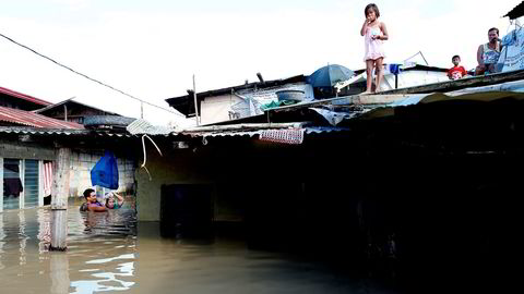 Et par tar seg gjennom vannmassene for å kjøpe drikkevann etter at tyfonen  Mangkhut rammet Filipinene i helgen og oversvømmet lavtliggende områder. Bildet er fra Calumpit i Bulacan-provinsen nord for Manila.