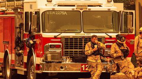 Slitne brannmannskaper tar en hvil i nærheten av Santa Rosa i California.
