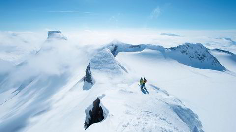 Brølende utsikt. Fra Sokse (2189 m.o.h.) ser Anne-May Slinning og Karsten -Gafle ned mot Bjørneskardet, hvor Høgruta pas-seres på turens siste dag. Til venstre ses den flate toppen på Storebjørn (2222 m.o.h.). Midt i bildet har toppen av Vesle-bjørn (2150 m.o.h.) tatt tåkehatten på.