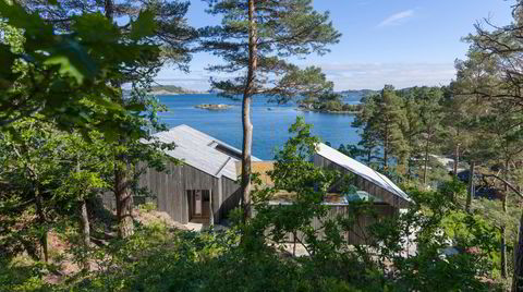 Oppfølger. Hytta ligger på en liten knaus, rammet inn av trærne rundt og med utsikt over skjærgården. Det er den andre hytta arkitekt Tommie Wilhelmsen har tegnet i Søgne.