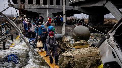 Krigen i Ukraina og mulig boikott av russisk olje sender olje- og gassprisene til værs. På bildet ser vi flyktninger fra Irpin i det nordvestliges Ukraina som krysser en ødelagt bro,