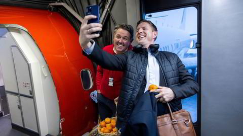 Norwegian-sjef Geir Karlsen (fra venstre) var tidligere i uken på Gardermoen for å ønske passasjerer og ansatte god jul. Passasjer Ølver Haveland var først ombord i 15.30-flyet til Bergen og benyttet anledningen til å få en klementin og en selfie.
