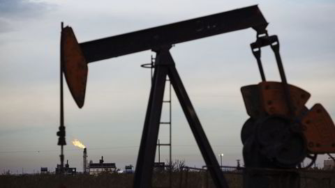 A gas flare burns past a pump jack in the Permian Basin area of Loving County, Texas, U.S., on Monday, Dec. 17, 2018. Once the shining star of the oil business, gasoline has turned into such a drag on profits that U.S. refiners could be forced to slow production in response. Photographer: Angus Mordant/Bloomberg