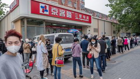 Innbyggere i Beijing venter i kø for å slippe inn ved en matbutikk i den kinesiske hovedstaden. Nesten 300 millioner innbyggere i Kina er for tiden underlagt restriksjoner.