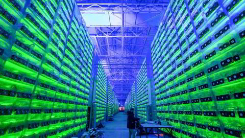 A worker inspects hardware devices at a mining farm in Nadvoitsy, Russia.