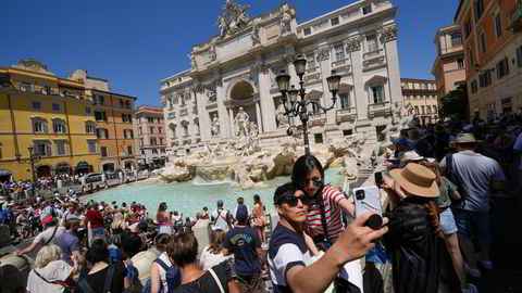 Turister tar en selfie foran Trevifontenen i Roma.