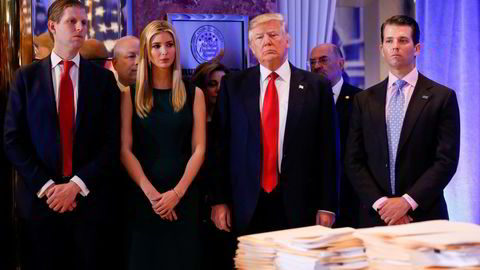Donald Trump omgitt av tre av sine barn. Det er Donald Trump jr. (til høyre) og Ivanka Trump som er blitt stevnet sammen med faren. Helt til venstre er Eric Trump.