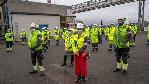 Arbeidere med ansiktsmasker i ulike aldre bivåner åpningen av testanlegget for CO2-transport i rør på Equinor Herøya.
