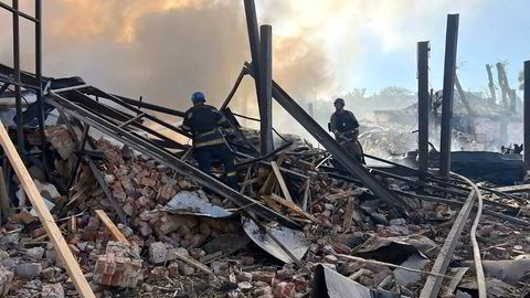 Ukrainske redningspersonell slukker branner etter et russisk angrep i Kryvyj Rih fredag.