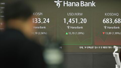 Tv cameraman films near the screens showing the Korea Composite Stock Price Index (KOSPI), left, the foreign exchange rate between U.S. dollar and South Korean won, center, and South Korean won and the Korean Securities Dealers Automated Quotations (KOSDAQ) at a foreign exchange dealing room in Seoul, South Korea, Thursday, Dec. 19, 2024. (AP Photo/Lee Jin-man)