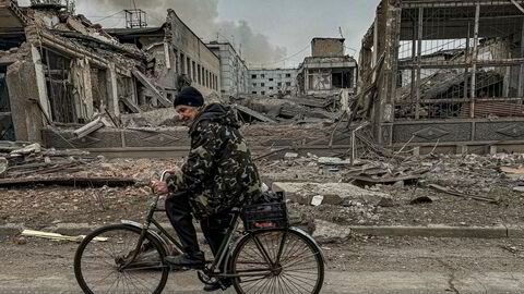 En mann sykler gjennom utbombede områder av byen Kurakhove i Donetsk-regionen. Russerne er på frammarsj. Mange innbyggere har valgt å evakuere, mens andre biter seg fast.