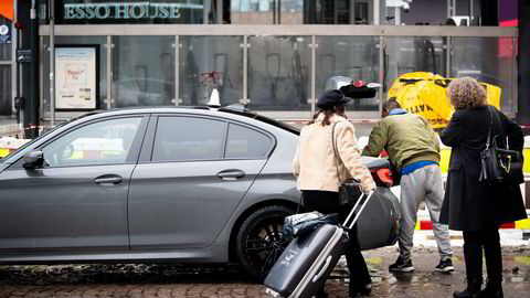 Et par kunder på vei inn i en taxi utenfor sentralbanestasjon i Oslo sentrum.