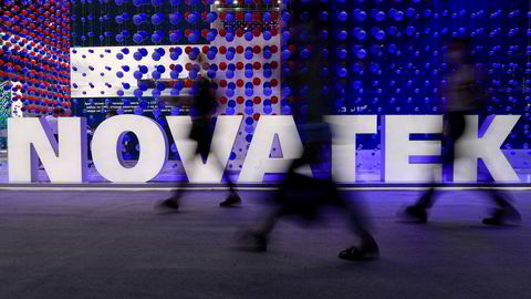 Forbipasserende går forbi logoen til en av Russlands største aktører på energifeltet, Novatek, under St. Petersburg International Economic Forum.