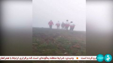 Redningsarbeidere på vei mot ulykkesstedet preget av regn og tåke. Bildet er fra iransk tv, Irinn.