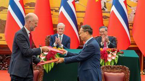 Norges ambassadør til Kina Vebjørn Dysvik, statsminister Jonas Gahr Støre og Kinas statsminister Li Qiang signerer en felles klimaavtale i Folkets store sal i Beijing tirsdag.