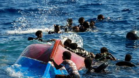 Migranter svømmer nær deres veltede båt ved den italienske øyen Lampedusa. EU strammer inn for at færre skal ta den farlige ferden.
