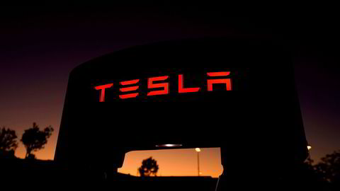 En Tesla lader i solnedgang i California