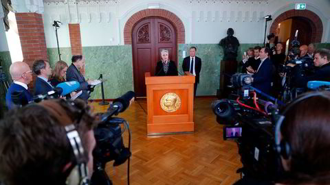 Berit Reiss-Andersen, leder av Nobelkomiteen, og komiteens sekretær Olav Njølstad (i bakgrunnen), offentliggjør her vinneren av fredsprisen på Nobelinstituttet i Oslo.