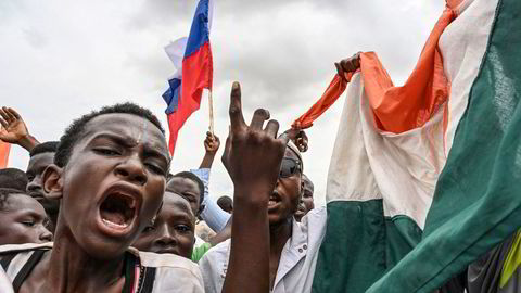 Tilhengere av militærjuntaen i Niger vifter med russiske og nigerske flagg utenfor en fransk militærbase i landet.
