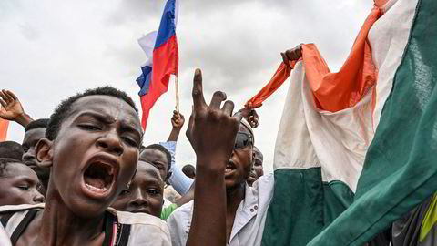Tilhengere av militærjuntaen i Niger vifter med russiske og nigerske flagg utenfor en fransk militærbase i landet.