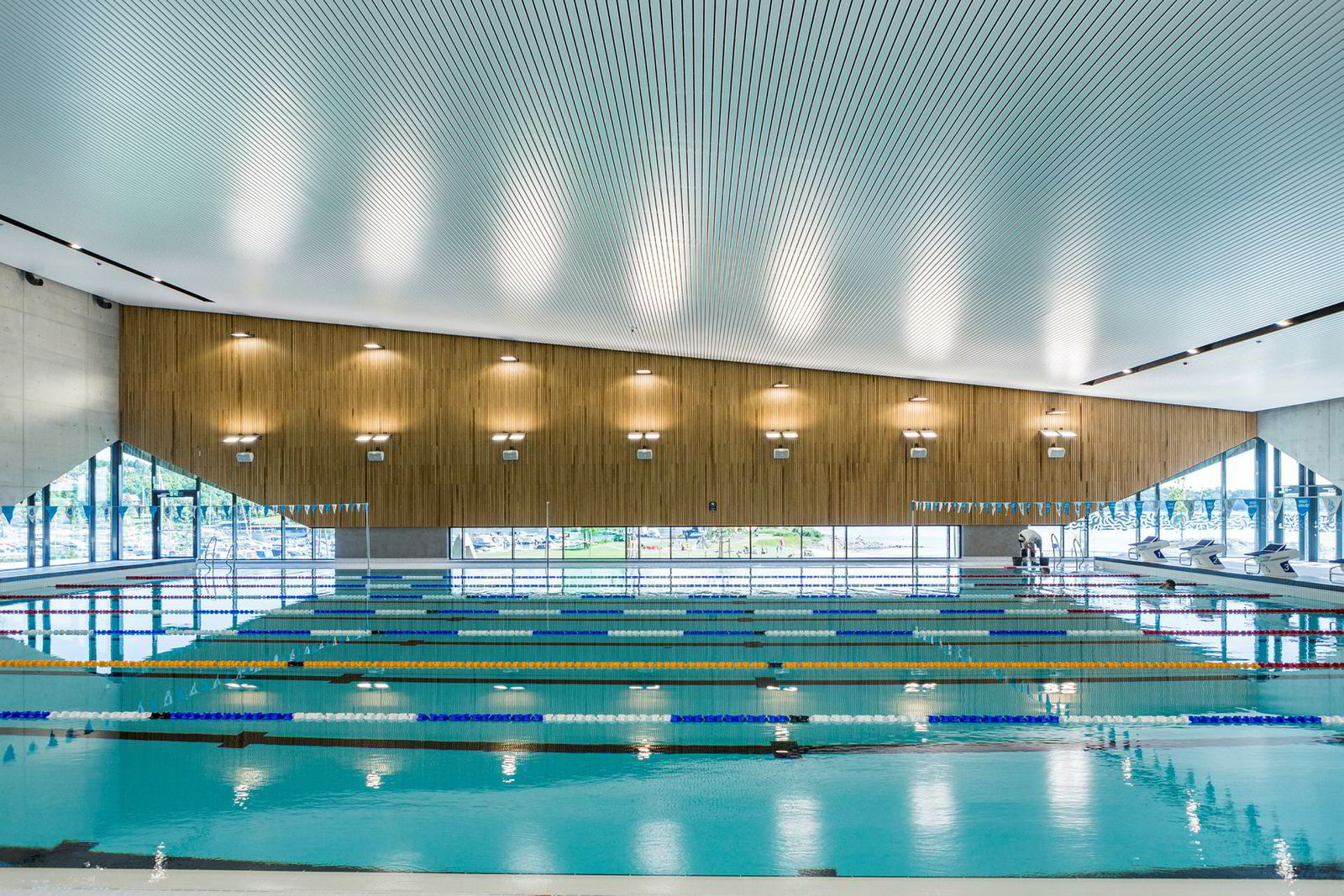 Dekket av solceller og solfangere, bruker Holmen Svømmehall 45 prosent mindre energi enn en tilsvarende hall. Under bakken ligger geobrønner som fylles opp om sommeren og tappes om vinteren. Alt monitoreres og analyseres, slik at så lite energi som mulig går til spille.