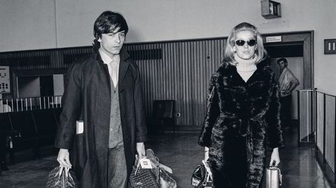 Stjernepar. Den britiske motefotografen David Bailey og den franske skuespilleren Catherine Deneuve var bare gift i to år. Her er de på London Airport i mars 1966, der Bailey bærer sine vesker og kofferter fra Louis Vuitton med samme selvsagthet som undertegnede bærer Rema-poser med tacosett en fredagsettermiddag.