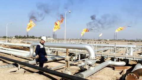 En arbeider går i mellom oljerørledninger på oljefeltet Nahr Bin Umar i Irak.