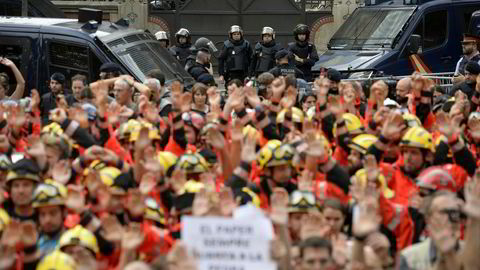 Brannmenn løfter nevene i protest mot politiets fremferd i forbindelse med søndagens folkeavstemning. Store deler av Barcelona ble lammet under tirsdagens generalstreik.
