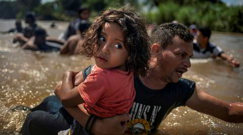 Luis Acosta hjelper femåringen Angel Jesus, begge fra Honduras, over Suchiate-elven mellom Mexico og Guatemala. Fotograf Adrees Latif vant Pulitzer-prisen for bildet i fjor, i kategorien «breaking news».