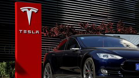 Rapport spår at Tesla vil miste lederposisjonen blant verdens produsenter av elbiler. FILE PHOTO: A Tesla car charges at a charging station in Beijing, China, April 18, 2017. REUTERS/Thomas Peter/File Photo