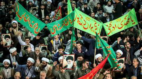 En gruppe iranere marsjerer i støtte for regjeringen etter at det siden torsdag har vært store protester mot regjeringen.