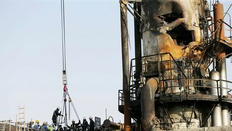 Arbeidere fikser en ødelagt plattform i Abqaiq, Saudi Arabia.